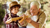 Little boy with older man at a swing