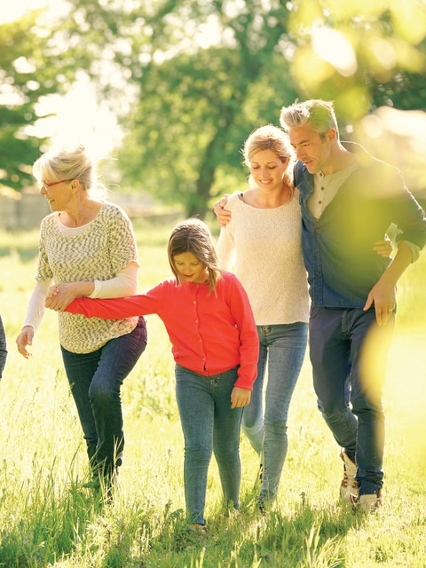 Happy family of 6 walking in park