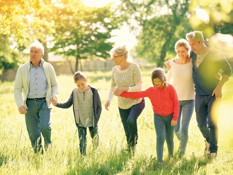 Happy family of 6 walking in park